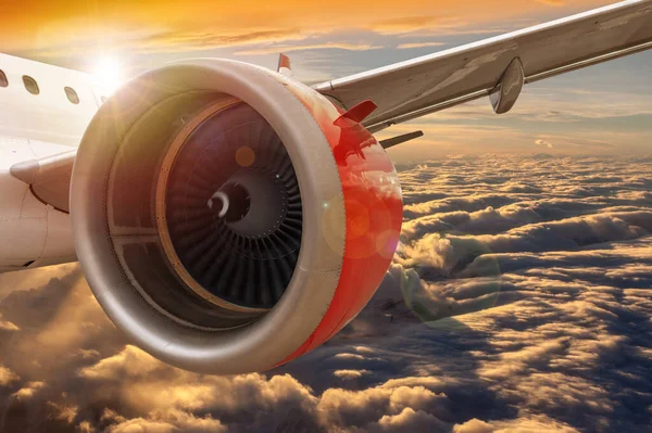 コピースペースと黄金の夕日の雲の上を飛ぶ飛行機の翼のクローズアップを示す航空概念 ビジネスやレジャーのための空気による旅行の概念 — ストック写真