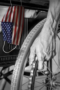 Tekerlekli sandalyedeki son sınıf öğrencisi siyah beyaz bir huzurevinde Amerikan bayrak maskesi takıyor. Amerikan huzurevlerinde ya da huzurevlerinde Covid-19 Coronavirüs salgını kavramı.