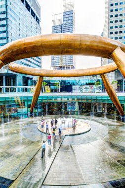 SINGAPORE - 26 Mart 2015: Turistler Zenginlik Pınarı 'na doğru yürüyorlar ve onu çevreleyen herkese 3 kez şans getirdiklerine ve ortadaki suya dokunduklarına inanılıyor. Dünyanın en büyük çeşmesi Suntec Ci 'nin ticari kompleksinde yer almaktadır.