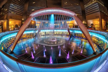 Singapur 'un Suntec şehrinde Zenginlik Çeşmesi gece aydınlanır. 1995 yılında inşa edilmiş, dünyanın en büyük çeşmesidir..