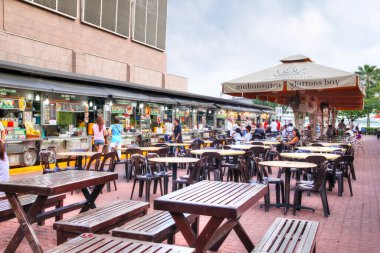 SINGAPORE - 7 Nisan 2011: Singapur 'daki Makansutra Gluttons Körfezi' nde yemek yiyen ziyaretçiler, ünlü Marina Körfezi 'nin yanındaki ucuz yerel sokak yemekleri satan popüler bir aşçılık merkezi..