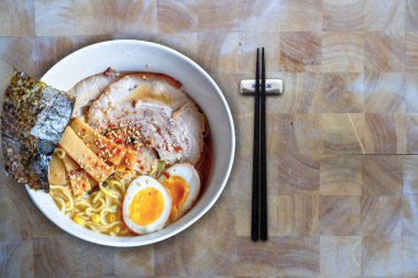 Ev yapımı Japon Char Siu veya Japon domuzu, yumurta sarısı, bambu filizleri, yosun ve susam bonitosuyla kaplı bol miso çorbalı bir kase Hokkaido rameni. Çubuklar ve kopyalama alanlarıyla.