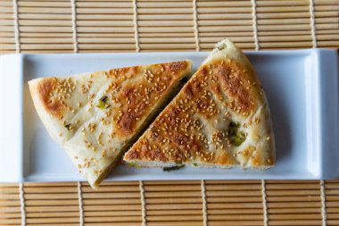 Kuzey Çin 'de popüler bir temel unsur olan susamlı soğanlı ekmek olarak bilinen Çin helal yiyeceklerine tepeden aşağı bakış. Ekmek taze soğanla doldurulmuş ve susamlı..