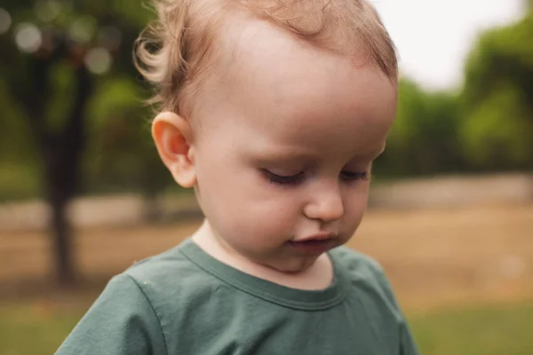 Twee jaar oude jongen staat op de achtergrond van de natuur — Stockfoto