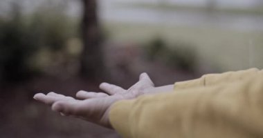 Yağmurda oynayan ve yağmurlu, kederli ve bulutlu bir günde evinin önünde ellerini ıslatan bir çocuğun ellerini kapatın / Toma cercana de las manos de un nio jugando en la lluvia y mojando sus manos fuera de su casa, nio en triste yaptı