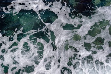 Açık turkuaz sudaki deniz köpüğü.