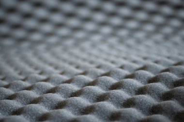 Seçici odaklı ve bokeh arkaplanlı gri ses geçirmez akustik köpüğün soyut dalgalı dokusu