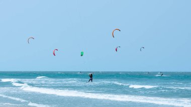Güzel turkuaz denizde bir yaz gününde uçurtma uçurmak.