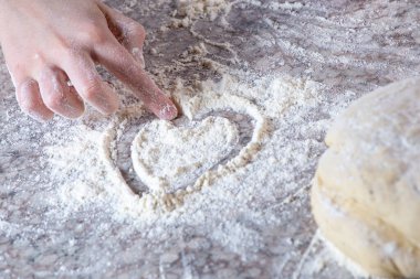 Beyazlı kız mutfakta pizza hamuru yapıyor.