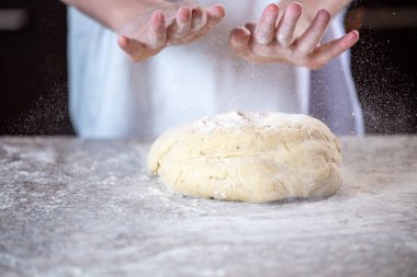 Beyazlı kız mutfakta pizza hamuru yapıyor.