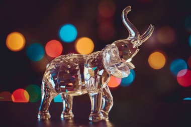 Bir kristal filin heykelciği Noel ışıklarının kapalı arka planında