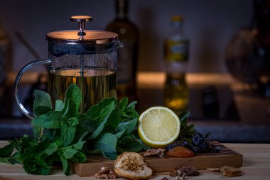 Meyveler, mutfak otları ve çay. Mutfakta hala hayat var. Nane, limon, kuru erik, ceviz, kuru elma ve kayısı.