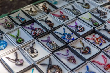 Eski Rodos şehrinin turistik bölgesindeki bir hediyelik eşya dükkanında boynundaki kolyeyle çeşitli renkte mücevherler.