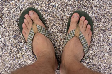 Sahilde çakıl taşları üzerinde insan ayağı