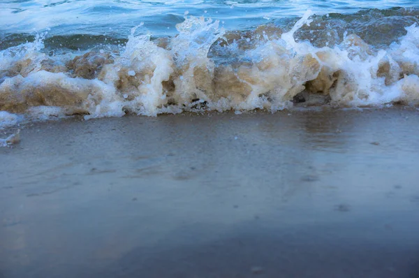 Sea surf, waves rolls on a sandy beach