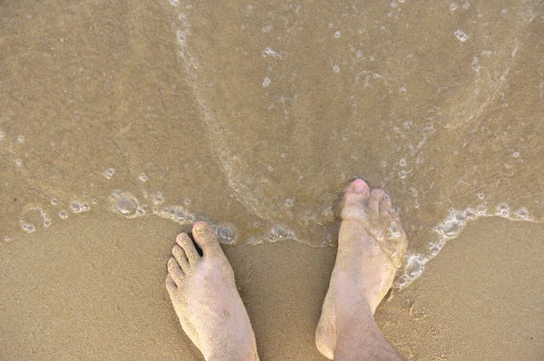 男人在沙滩上的脚 站在冲浪线附近 — 图库照片