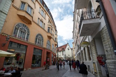 İnsanlar eski şehrin dar sokakları boyunca yürüyorlar. Yaz. Klasik balkonlar ve bir ev. tatil yapan turistler