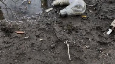 Camlar ve enerji tasarruflu ampuller sokaktaki çamur ve su birikintilerine atılır. Çevre kirliliği