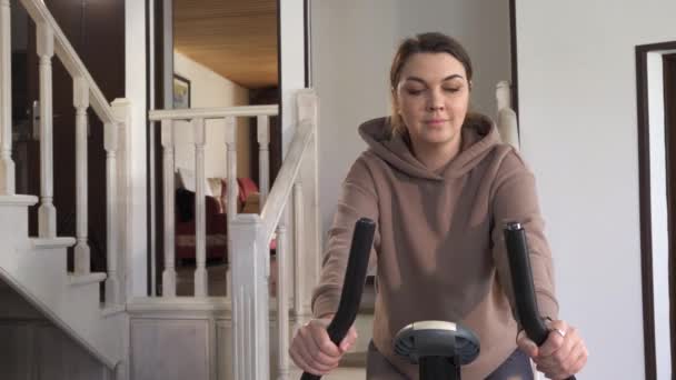Güzel Beyaz Kız Süveter Dar Eşofmanlı Evde Spor Bisikletiyle Pedal — Stok video