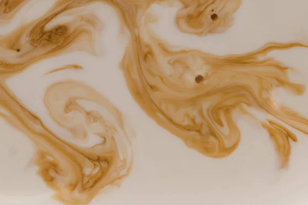 Brown stains in beige liquid with bubbles