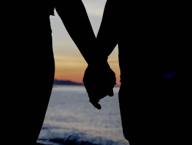 Sahilde birkaç ışık, el ele tutuşmalar, arka plandaki güzel gün doğumuna bakmalar.