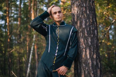 Seksi adam ormanda. Yeşil renk güzel, eski giysiler içinde. Ortaçağ. Fantezi. 