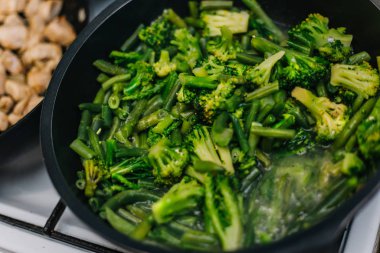 Kızartma tavasında haşlanmış sebze, brokoli ve taze fasulye..