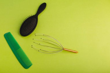 Yeşil arka planda yeşil ve siyah saç fırçası. Chesalka, baş masajcısı..