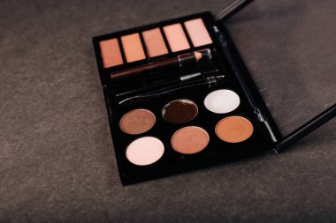 Gri arka planda göz farı paleti. Kaş, göz kapağı makyajı ve boya.