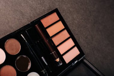 Gri arka planda göz farı paleti. Kaş, göz kapağı makyajı ve boya.