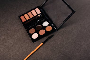 Gri arka planda göz farı paleti. Kaş, göz kapağı makyajı ve boya.