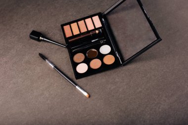 Gri arka planda göz farı paleti. Kaş, göz kapağı makyajı ve boya.