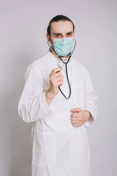 Doktor Stetoskopem Bílém Plášti Lékařskou Maskou Bílém Pozadí — Stock fotografie