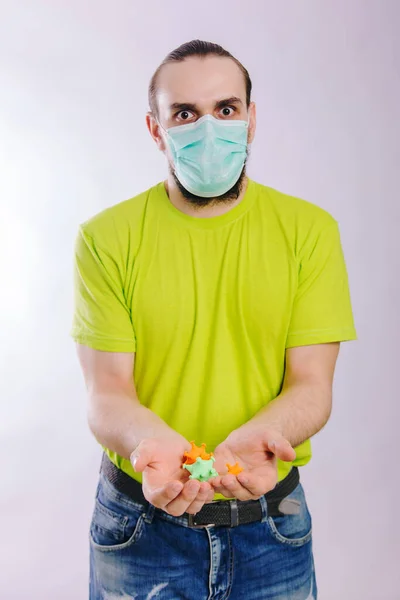 Ένας τύπος με πράσινο μπλουζάκι απλώνει το χέρι του με έναν κορωναϊό. Βρώμικα χέρια. Προσωπική υγιεινή. — Φωτογραφία Αρχείου
