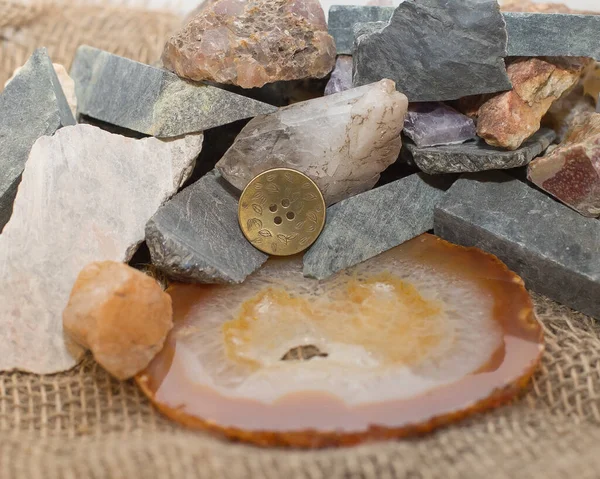 El yapımı metal düğme, arka planda Ural taşları kullanılır.