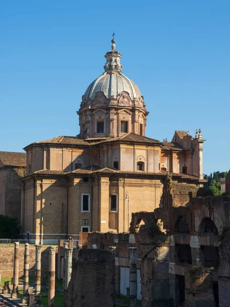 Roma, İtalya 'daki Roma Forum' unda bir yaz gününde antik kalıntılar. İmparator Septimius Severus 'un kemeri ve kilise Santi Luca ve Martina imparatorluk forumunda..