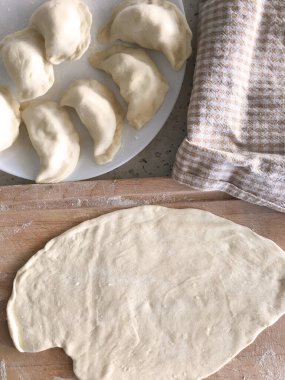 Tahtada hamur tatlısı için yuvarlanmış hamur, evde Rus köftesi hazırlığı.