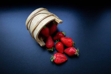 Dağınık yaban mersinleriyle çevrilmiş ahşap bir sepet.