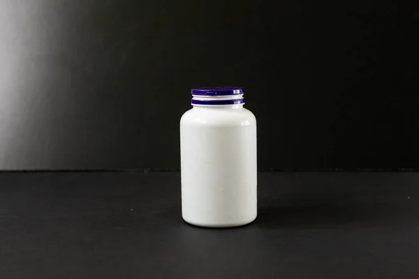 Ein Weißes Plastikgefäß Voller Pillen Auf Dunklem Hintergrund — Stockfoto