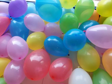 Balonlar tatil için hazır. Arka planda çok renkli birçok parça var.