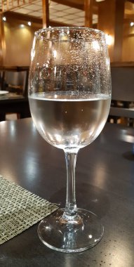 Restoranın arka planında misafirlerimizi bekleyen bir bardak su.