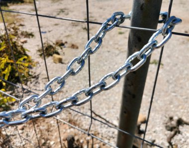 Demir kapıya bağlı bir zincir kapıyı kapatır ve çerçeveye uzanır.