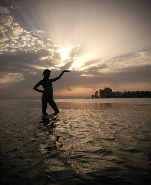 Piękny Zachód Słońca Chmurami Zachodzącym Słońcem Sylwetką Dziewczyny Stojącej Morzu — Zdjęcie stockowe