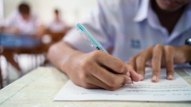 Sınav sorularını stresli bir şekilde cevaplayan okul öğrencileri. 16: 9 tarzı.