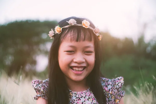 Χαριτωμένο Ασιατικό Κοριτσάκι Χαμογελά Στεφάνι Λουλούδι Στο Λιβάδι Τομέα — Φωτογραφία Αρχείου