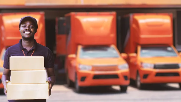 Gülümse Afrikalı adam. Posta kuryesi. Arabanın önünde teslimat yapıyor.