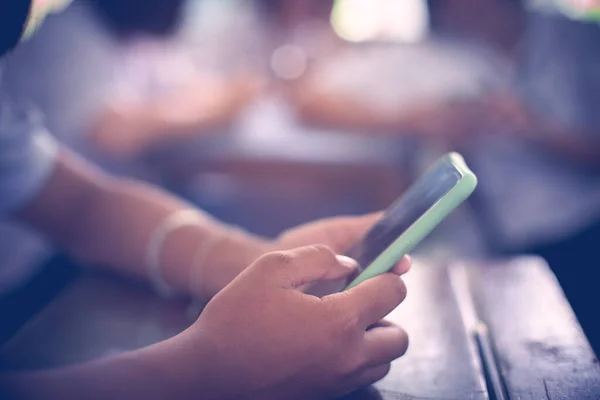 Sınıfta ders sırasında akıllı telefonlar kullanan bir grup öğrenci..