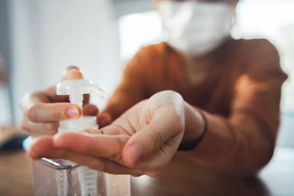 Corona virus protection, Closeup cleaning her hands with sanitizer gels, Woman in quarantine for coronavirus wearing protective mask, Working from home.