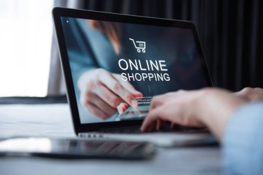 E-ticaret ve çevrimiçi alışveriş kavramı, dizüstü bilgisayar kullanan kadın eli (Mockup web sitesi) ve evde çevrimiçi alışveriş için kredi kartı bulunduruyor.
