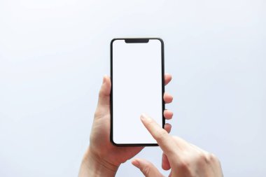 Akıllı telefon maketi. Siyah telefon beyaz ekranını tutarak elinizi kapatın. Beyaz arka planda izole edilmiş. Cep telefonu çerçevesiz tasarım kavramı.